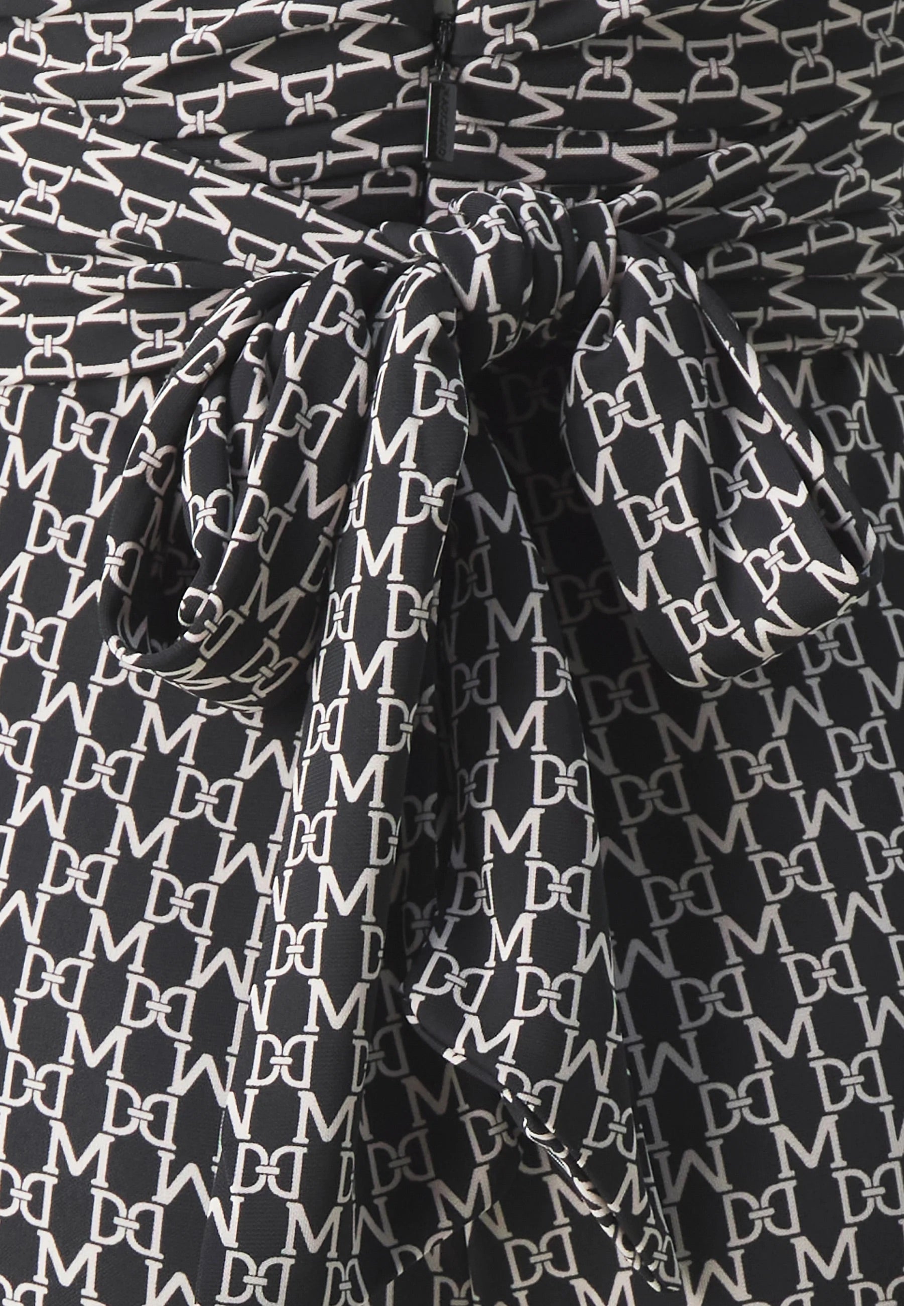 Close-up of the fabric detail of the Marciano by Guess New Kiki Jumpsuit – Black featuring elegant printed design.